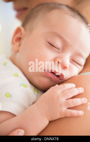 Baby boy (2-5 mesi) di dormire sulla madre di spallamento Foto Stock