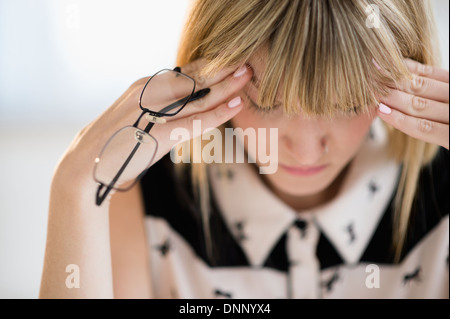 Donna con testa in mani Foto Stock