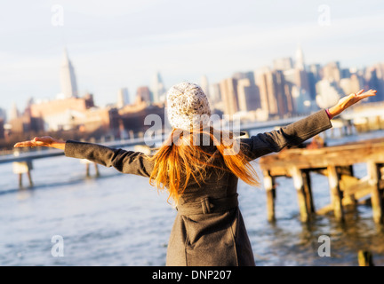 Stati Uniti d'America, la città di New York, Brooklyn, Williamsburg, vista posteriore della donna bionda con le braccia aperte Foto Stock