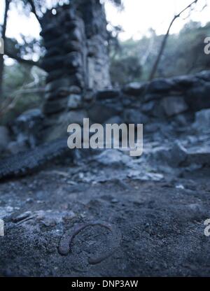 Trabuco Canyon, California, USA. Il 2 gennaio, 2014. Le braci erano ancora di fumare il giovedì mattina a cabin 10 lungo Trabuco Creek. La cabina, costruito nei primi anni Quaranta era sopravvissuto dozzina di incendi negli anni che si era diffuso attraverso la zona---ferro di cavallo si siede nella sporcizia all'ingresso posteriore della cabina 10. Credito: ZUMA Press, Inc./Alamy Live News Foto Stock