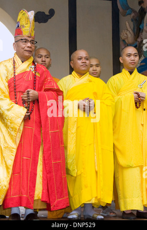 Capo monaco conduce altri monaci in preghiera buddista alla celeste signora (Pagoda Thien Mu).Tonalità, Vietnam. Foto Stock