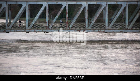 Bristol, Regno Unito. Il 3° gennaio 2014. Pendolari fanno la loro strada attraverso un ponte su un fiume gonfio Avon in Bristol seguenti alte maree e heavy rain. 3 gennaio 2014 Credit: Adam Gasson/Alamy Live News Foto Stock