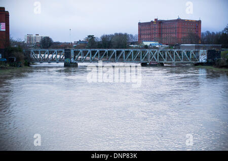 Bristol, Regno Unito. Il 3° gennaio 2014. Pendolari fanno la loro strada attraverso un ponte su un fiume gonfio Avon in Bristol seguenti alte maree e heavy rain. 3 gennaio 2014 Credit: Adam Gasson/Alamy Live News Foto Stock