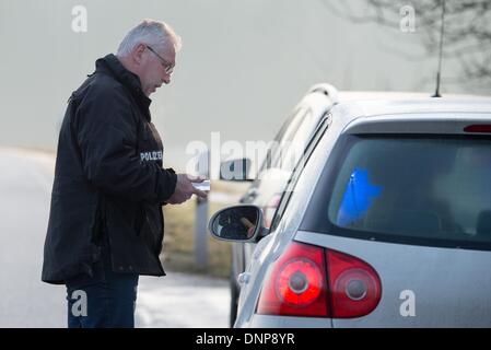 Schwandorf, Germania. 03 gen 2014. Un funzionario della cosiddetta Schleierfahndung, il controllo delle persone senza sospetto, controlla un veicolo in Schwandorf, Germania, 03 gennaio 2014. Ministro degli interni bavarese piani di lotta alla criminalità transfrontaliera con significativamente più controlli e una maggiore presenza della polizia. Foto: ARMIN WEIGEL/dpa/Alamy Live News Foto Stock