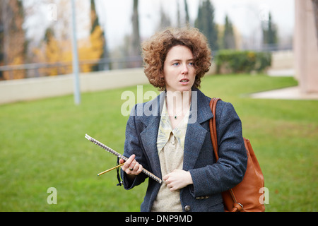 Femmina studente redhead che porta notebook a campus universitario Foto Stock