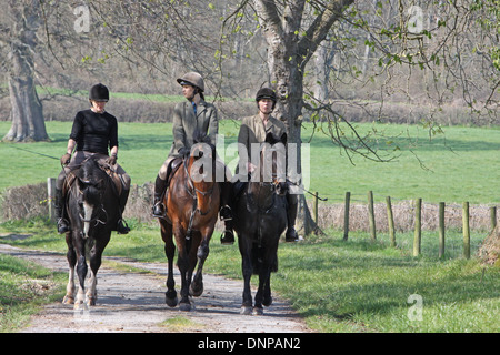 Cavalli e Cavalieri hacking fuori in una tranquilla strada di campagna Foto Stock