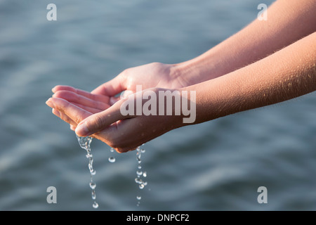 Donna con le mani gocce d'acqua Foto Stock