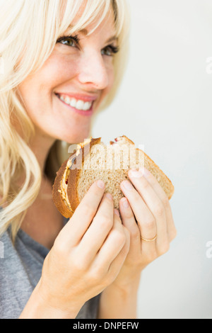 Donna di mangiare panino con burro di arachidi Foto Stock