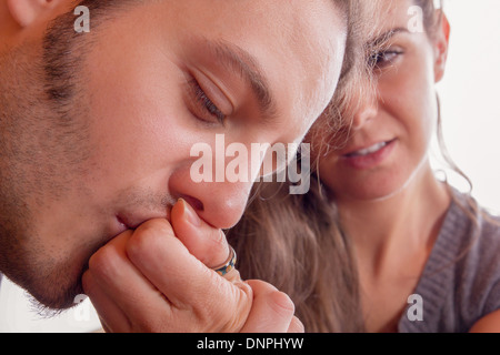 Uomo baci delicatamente la mano della sua fidanzata con passione Foto Stock