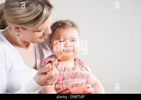 Ritratto di Madre Figlia di alimentazione, Studio Shot Foto Stock