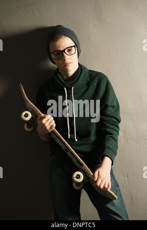 Ritratto di ragazzo con lo skateboard, Studio Shot Foto Stock