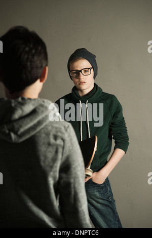 Ragazzo con lo skateboard parlando al ragazzo adolescente, Studio Shot Foto Stock