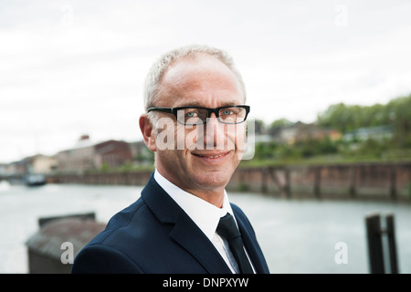 Ritratto di coppia uomo d affari esterni, indossando il corno-bordati di occhiali, sorridente alla fotocamera, Mannheim, Germania Foto Stock