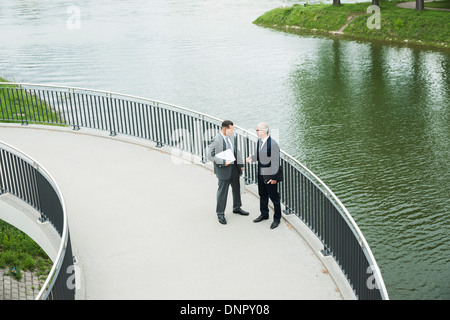 Imprenditori matura in piedi sul marciapiede parlando, Mannheim, Germania Foto Stock