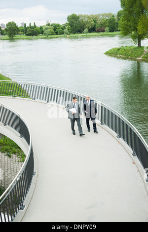 Coppia imprenditori sul marciapiede parlando, Mannheim, Germania Foto Stock