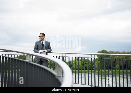 Imprenditore maturo in piedi sul ponte, Mannheim, Germania Foto Stock