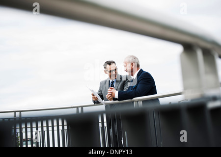 Imprenditori matura in piedi sul ponte parlando, Mannheim, Germania Foto Stock