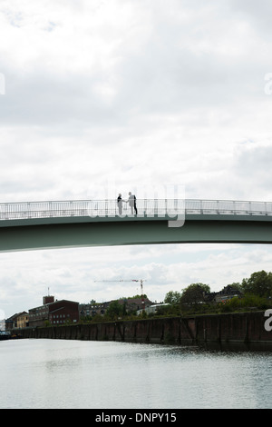 Silhouette di imprenditori matura in piedi sul ponte agitando mani, Mannheim, Germania Foto Stock