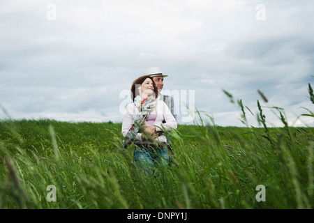 Coppia matura in piedi nel campo di erba, abbracciando, Germania Foto Stock