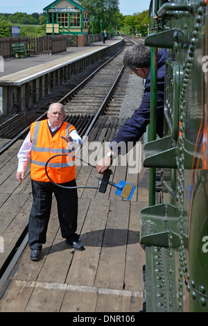 Lo scambio di token è stato consegnato dal conducente del motore al signalman alla fine della singola pista che lavora sulla ferrovia storica Epping Ongar Foto Stock