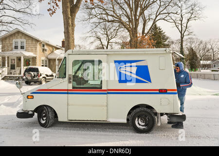 Merrick, New York, Stati Uniti Il 3 gennaio 2014. Un Servizio Postale degli Stati Uniti USPS carrello e gestore di posta recapitare la posta come una pericolosa Deep Freeze si assesta dopo un blizzard oggetto di dumping 6-12 cm di neve su Long Island. Il range di temperatura è 13 a 18 gradi Fahrenheit (-11° a -8° Celsius), con presenza di raffiche di vento fino a 45 km/h. Wind chill fattori la rendono tra 5° F a -10° F (-15° a -23° C), con un record di bassi previsto in notturna. Credito: Ann e Parry/Alamy Live News Foto Stock