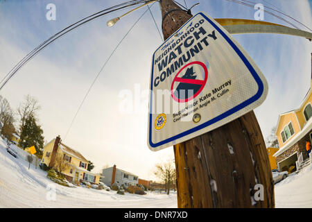 Merrick, New York, Stati Uniti Il 3 gennaio 2014. Neighborhood Watch Community sign telai sul palo della luce lungo la strada innevata come una pericolosa Deep Freeze si assesta dopo un blizzard oggetto di dumping 6-12 cm di neve su Long Island. Il range di temperatura è 13 a 18 gradi Fahrenheit (-11° a -8° Celsius), con presenza di raffiche di vento fino a 45 km/h. Wind chill fattori la rendono tra 5° F a -10° F (-15° a -23° C), con un record di bassi previsto in notturna. Credito: Ann e Parry/Alamy Live News Foto Stock