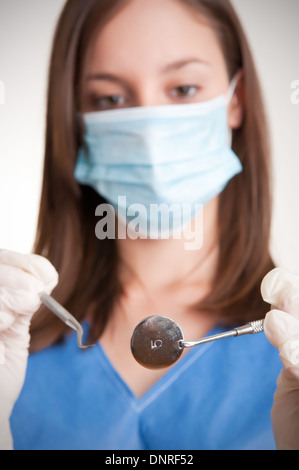 Primo piano di un dentista mani circa per eseguire un intervento su un paziente Foto Stock