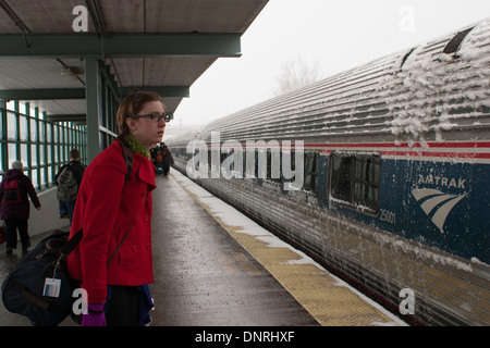 Una giovane donna attende a bordo di un treno Amtrack legata a Boston per un inverno nevoso giorno. Foto Stock