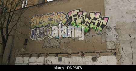 Coloratissimo graffito scrawl sul cemento grigio rendono il parco auto della parete edilizia, vicino le rughe della città murale, Rosenthaler Strasse, Berlino Foto Stock