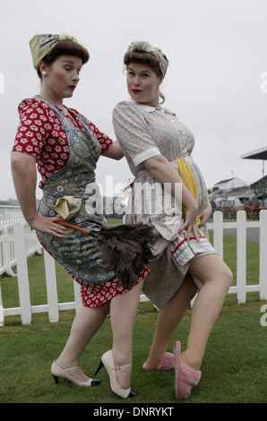 Due donne in posa vestito negli anni cinquanta a 'char lady' costumi a Goodwood races Foto Stock