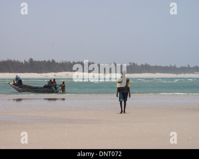 I pescatori a Langue de Barbarie, Saint Louis, Senegal che preparano la loro imbarcazione. Foto Stock