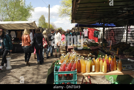 Sunny View gente camminare passato bottiglie di succo di mela su un tavolo a una bancarella vendendo prodotti della fattoria, Mauerpark Mercato delle Pulci, Berlino Foto Stock