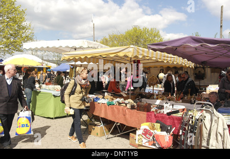 Blue sky nuvole bianche visualizza la gente camminare passato bancarella vendendo ornamenti, lampade, scarpe, vestiti, Mauerpark Mercato delle Pulci, Berlino Foto Stock