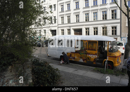 Vista, a bianco appartamenti, lady bianco inginocchiato vaso di vernice, pittura a mano graffiti scrawl autobus gialli, Christinenstrasse, Berlino Foto Stock