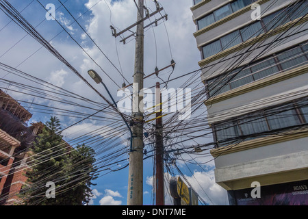 Tangled elettrici e di cablaggio telefonico in Bolivia causando un vero e proprio caos complesse per i tecnici che lavorano su linee. Foto Stock