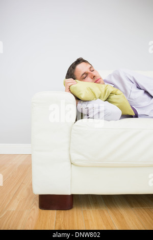 Imprenditore stanco di dormire sul divano nel soggiorno Foto Stock