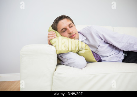 Imprenditore stanco di dormire sul divano nel soggiorno Foto Stock