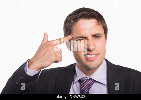 Imprenditore tenendo le dita contro il tempio nel gesto della pistola Foto Stock