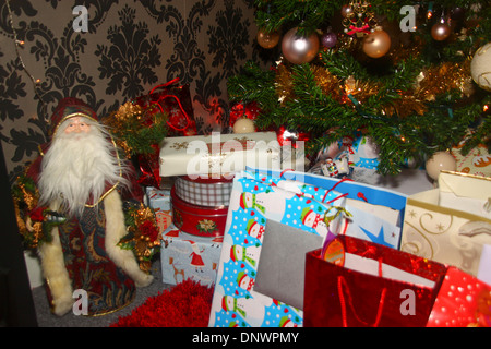 Santa Claus fregio sotto albero di Natale con regali impacchettati Foto Stock