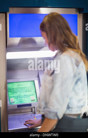 Studente immettendo il pin presso l'atm Foto Stock