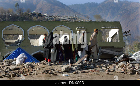 Dic 05, 2005; città di Balakot, PAKISTAN; conseguenze del terremoto in Pakistan del 8 ottobre 2005. Una famiglia rende la loro strada attraverso un mucchio di macerie e dove un hotel una volta era nel centro della città di Balakot città del Pakistan. Credito: Foto di Nelvin Cepeda/San Diego raccordo T/ZUMA premere. (©) Copyright 2005 da San Diego raccordo T Foto Stock