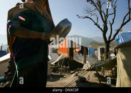 Dic 05, 2005; città di Balakot, PAKISTAN; conseguenze del terremoto in Pakistan del 8 ottobre 2005. In possesso di un recipiente di cottura, questa signora fa la sua strada verso il bordo del la Belapudna camp, dove ella sarà dato di riso cotto a condividere con la sua famiglia. Tutti i giorni di volontariato gruppi religiosi passano al di fuori di riso cotto per coloro che vivono in tende di emergenza. Credito: Foto di Nelvin Cepeda/San Diego Foto Stock