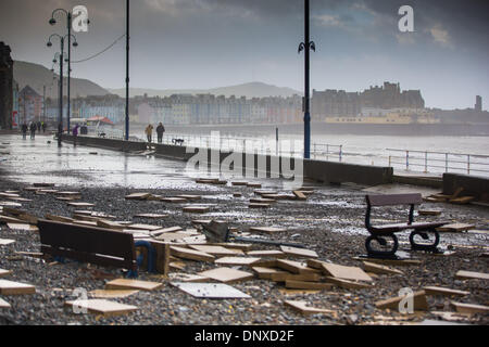 Aberystwyth, Wales, Regno Unito. Il 6 gennaio, 2014. La scena seguente mattina alta marea a Aberystwyth. L'iconico rifugio pubblico cede sulla spiaggia come un massiccio buco è scavato dalle onde. I detriti sparsi lungo la strada e i marciapiedi di nuovo. La città balneare di Aberystwyth, ancora scosso da danni rilevanti causati da onde enormi nel corso di diversi giorni, è stata martoriata nuovamente a alta marea il 6 gennaio. Raffiche di 70 mph e un enorme rigonfiamento causato ondate di rompersi nel mare delle difese, i residenti del Lungomare degli edifici per essere evacuato e il lungomare per essere cordoned-off dalla polizia. Credito: atgof.co/Alamy Live News Foto Stock