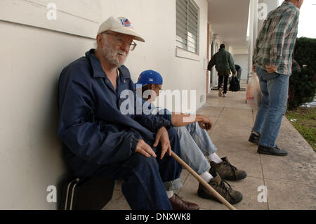 Jan 05, 2006; Riviera Beach, FL, Stati Uniti d'America; senzatetto uomini attendere per un pasto di mezzogiorno al di fuori di San Giorgio Chiesa Episcopale in Riviera Beach, FL. La città il sindaco vuole utilizzare un controverso eminente dominio della legge alla riqualificazione di area e di eliminare i senzatetto e disoccupati. Credito: Foto di Robin Nelson/ZUMA premere. (©) copyright 2006 di Robin Nelson Foto Stock