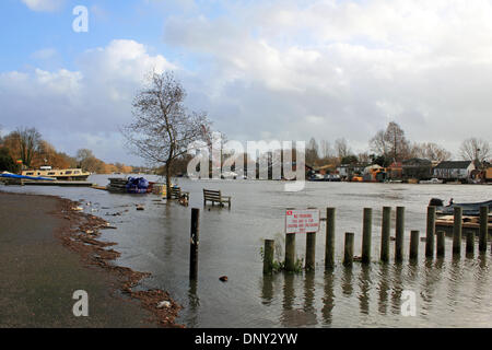 Hampton, Surrey, Inghilterra, Regno Unito. Il 6 gennaio 2014. Come il maltempo continua a portare heavy rain in tutta l'Inghilterra il Tamigi ha scoppiare le sue banche vicino Hampton Sailing Club on Thames Street. Nessun segno di parcheggio in allagato la Vela Club parcheggio con panche sommerse e detriti depositati a marea alta linea. Case e barche ormeggiate su Taggs Island sull'altra sponda del Tamigi sono anche in pericolo di allagamento se i livelli dell'acqua più aumentare. Credito: Julia Gavin/Alamy Live News Foto Stock