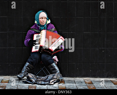 Donna busker in strada con fisarmonica Foto Stock