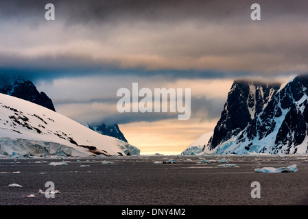 Lemaire Channel Landscape Antartide // LEMAIRE CHANNEL, Antartide - il paesaggio panoramico del Lemaire Channel, con ripide scogliere di montagna che si innalzano dall'acqua su entrambi i lati e il bagliore del sole mattutino in lontananza. Il canale di Lemaire è talvolta chiamato "Kodak Gap" in riferimento alle sue viste panoramiche. Foto Stock