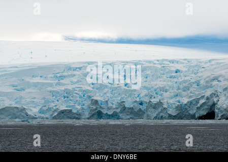 CANALE DI LEMAIRE, Antartide: Le scogliere glaciali si innalzano dall'acqua lungo Booth Island sulla costa occidentale del canale di Lemaire. Queste aspre formazioni di ghiaccio fanno parte del suggestivo paesaggio che ha fatto guadagnare a questo passaggio della Penisola Antartica il soprannome di "Kodak Gap". I ghiacciai dimostrano l'interazione dinamica tra ghiaccio e oceano nell'ambiente costiero antartico. Foto Stock