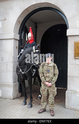Un soldato britannico "turisti" pone con montato un corpo di guardia del Blues e Royals in servizio presso il cavallo la caserma delle guardie, Londra, Regno Unito. Foto Stock