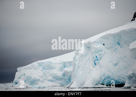 Antartide - un ghiacciaio di uno spesso strato di ghiaccio e neve scende gradualmente nel mare come esso fluisce giù per il fianco della montagna presso il canale di Lemaire in Antartide. Il Lemaire Channel è talvolta indicata come "Kodak Gap' in un cenno al suo famoso vedute panoramiche. Foto Stock